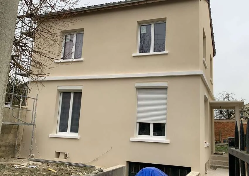 Façade enduite et menuiseries d’une maison rénovée à Louvres